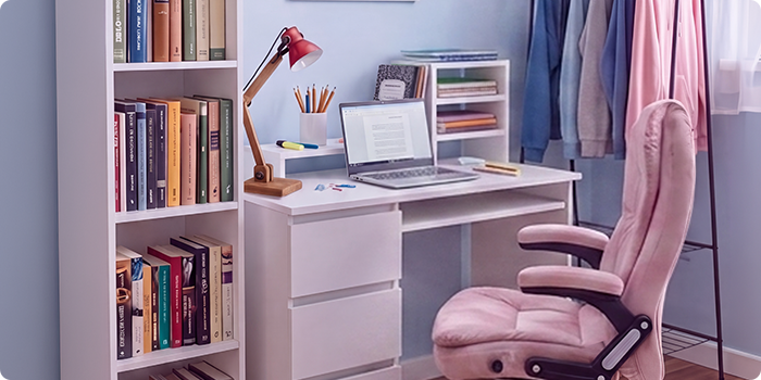 Moderní studentský studijní prostor s bílým psacím stolem, ergonomickou kancelářskou židlí, notebookem, knihovnou, úložnou skříňkou a věšákem na oblečení ve světlé, uspořádané ložnici navržené pro pohodlné studium i každodenní studentský život.