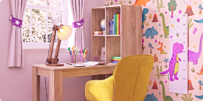 Světlý dětský studijní pokoj s dřevěným psacím stolem, ergonomickou žlutou židlí, stolní lampou, úložnou policí a tapetou s dinosaury, ideální pro vytvoření uspořádaného a pohodlného místa na učení doma.